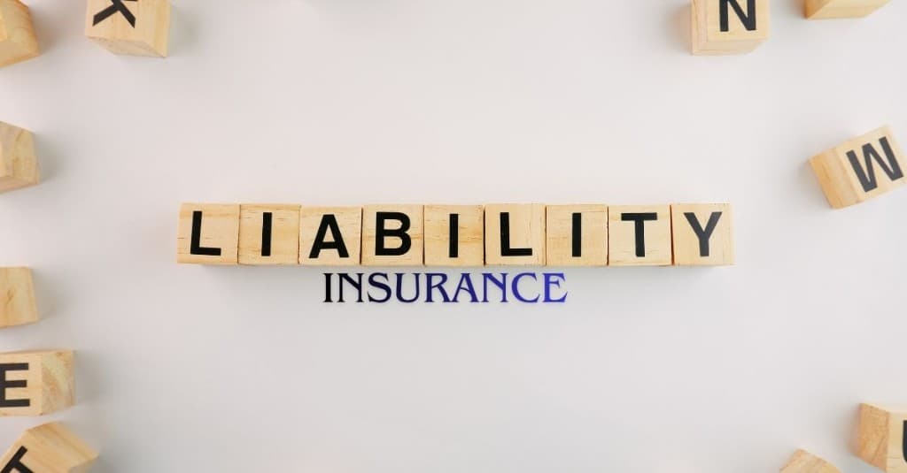 Workplace injury scene in an industrial setting with workers in safety gear; liability insurance banner